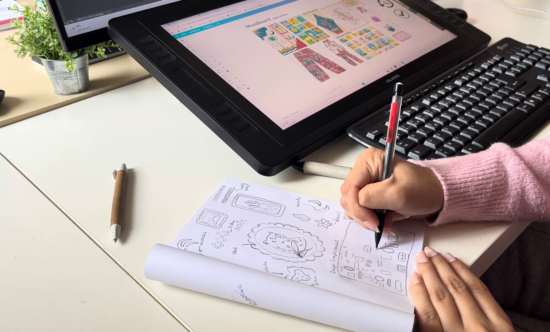 Croquis dessinés à la main devant une tablette graphique affichant une planche d’inspiration